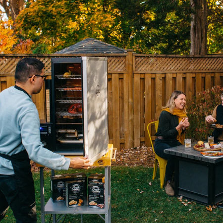 Bradley Digital 4-Rack Electric Smoker in use at backyard party