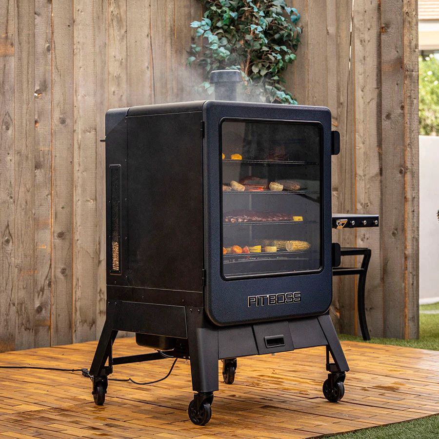 Outdoor angled view of the Pit Boss Navigator 6 Series Smoker in use, smoking meats and vegetables.