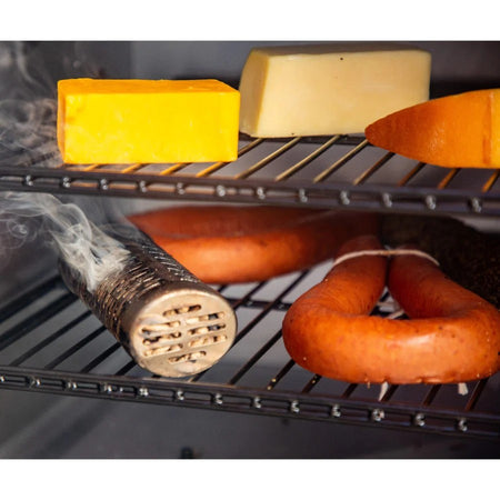 A-Maze-N 6-inch tube smoker filled with pellets, generating smoke on a barbecue grate