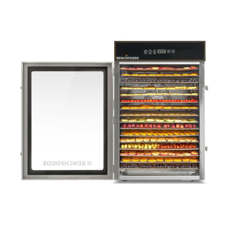 Straight-on wide framing of a BenchFoods 16-tray dehydrator with an open door, showcasing massive capacity and uniform rows of assorted fruits.