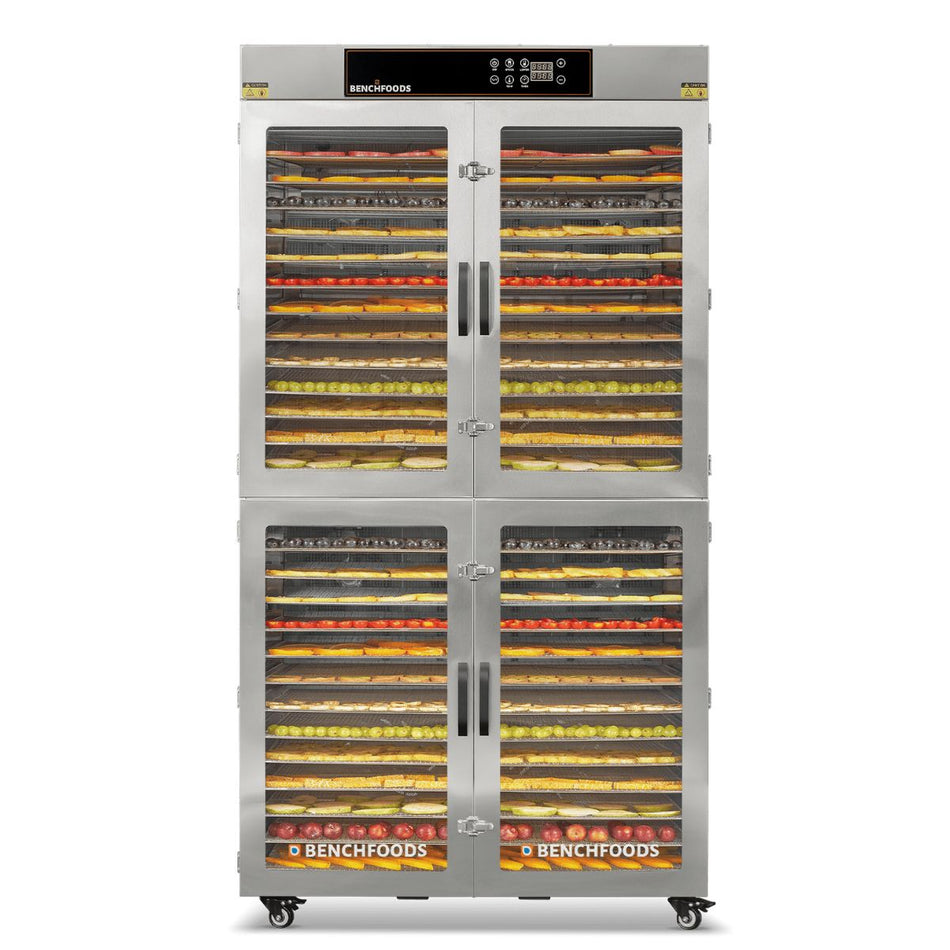 Front studio view of the BenchFoods 28CUDG commercial dehydrator with all four glass display doors closed, showing stacked layers of dehydrating fruit.