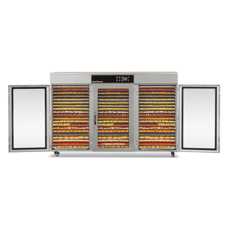 Front straight-on view of the BenchFoods 60CUDG commercial dehydrator with the left and right doors open, showing all 60 trays completely full of dehydrated fruits.