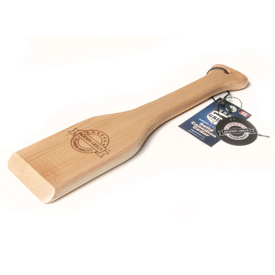 Angled view of Jackson Grills cedar wood scraper with tag and branding