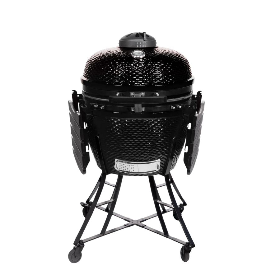 Louisiana Grills 24" Ceramic Kamado Charcoal Grill with foldable side shelves, showing its compact design for easy storage and mobility.