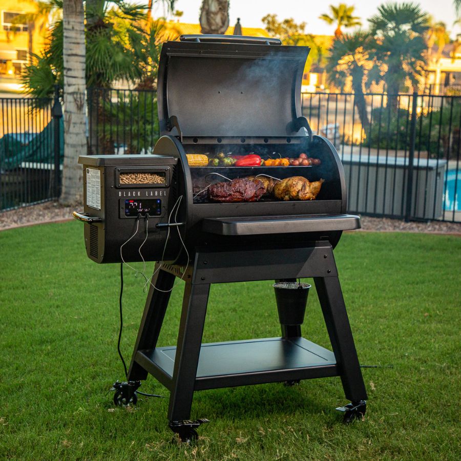 Louisiana Grills 800 Black Label pellet grill in use, loaded with sizzling meats and vegetables, delivering rich wood-fired flavor.