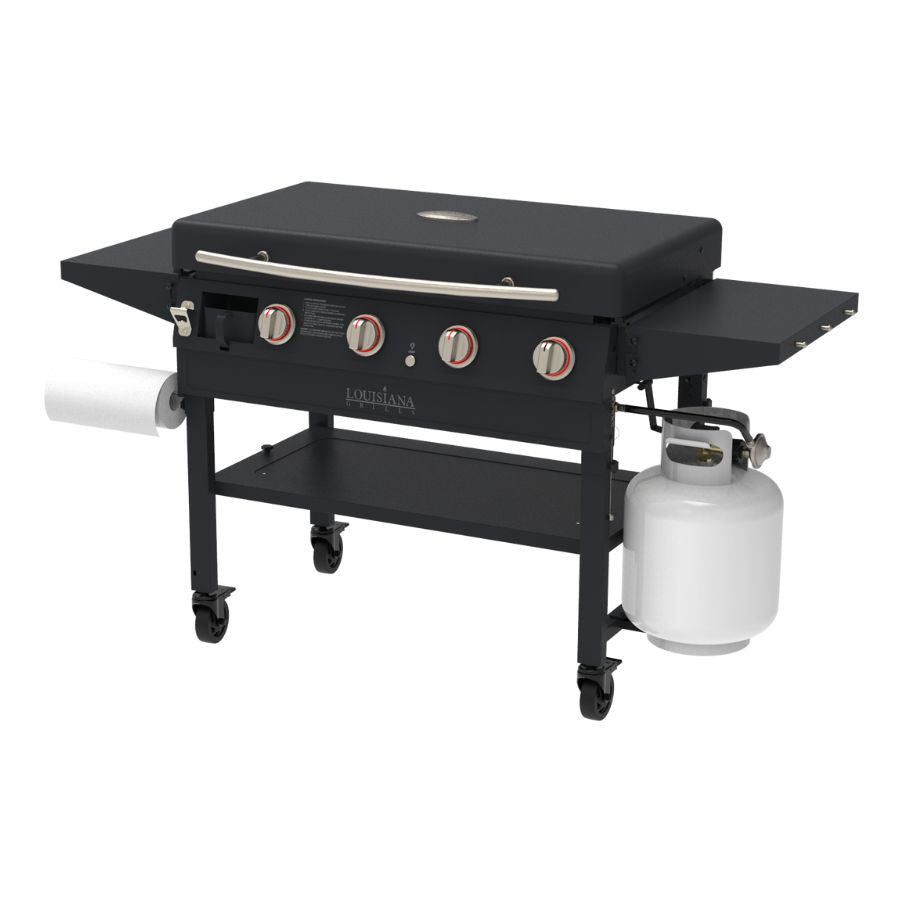 Louisiana Grills Founders Series 4-Burner Gas Griddle with stainless steel knobs, side shelves, and propane tank attachment, ideal for outdoor cooking and grilling.