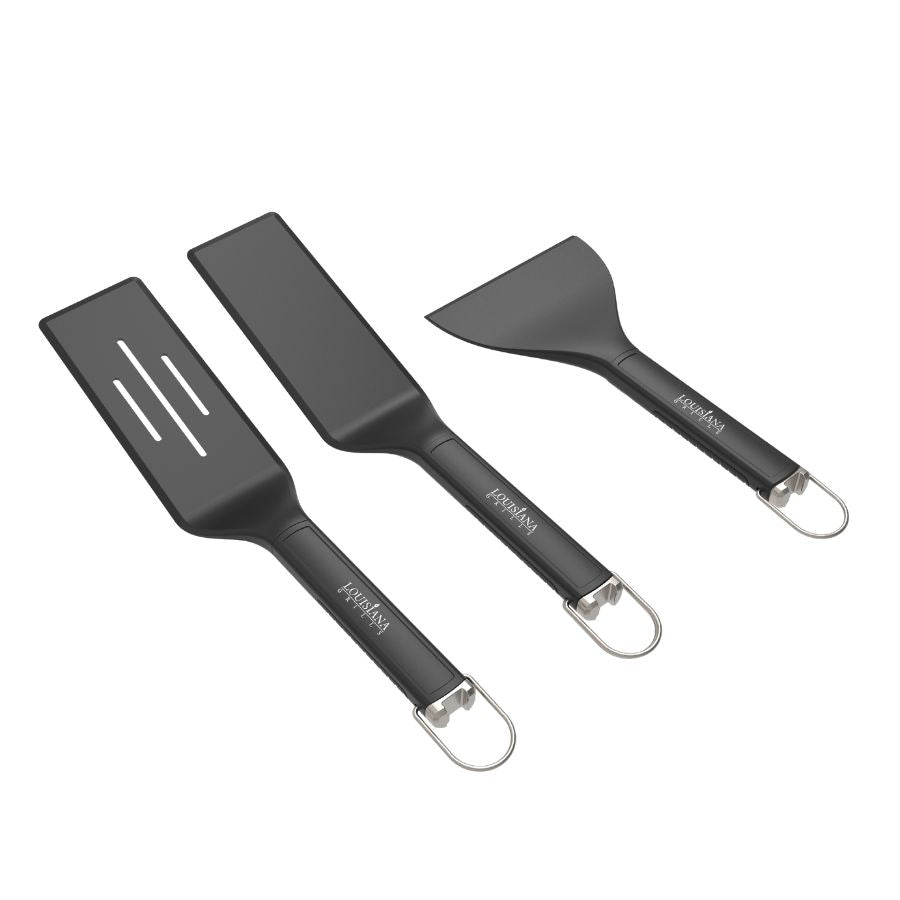 Louisiana Grills Founders Series Griddle Tool Set featuring three black-handled utensils, including a slotted spatula, solid spatula, and scraper for grilling and cooking.