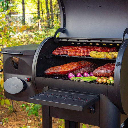 Louisiana Grills Founders Series Premier 800 Pellet Grill in action, cooking ribs, brisket, and vegetables with wood pellet smoke.