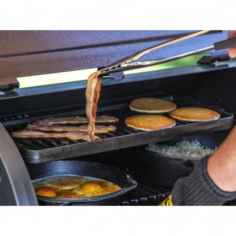 Breakfast foods, including eggs and sausages, sizzling on a Pit Boss 10 x 20 Cast Iron Griddle