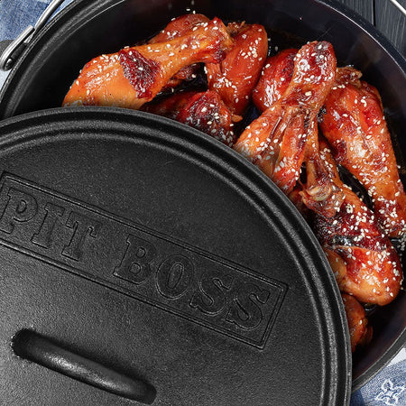 Pit Boss 12-inch Cast Iron Dutch Oven on a grill grate, with steam rising from food inside