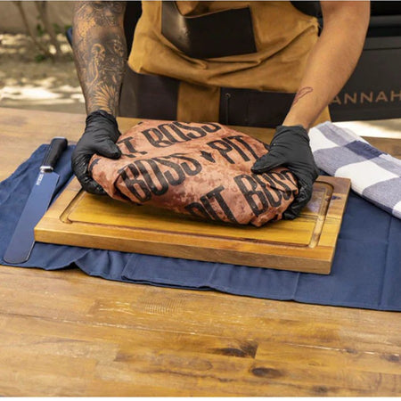 Pit Boss peach butcher paper being used to wrap a large cut of meat for smoking