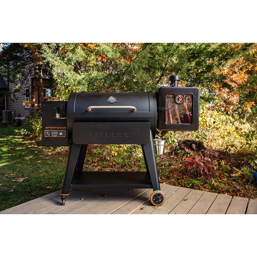 Pit Boss Side Smoker Attachment connected to a main grill, in an outdoor setting.