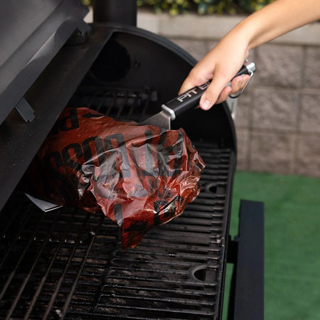 The Pit Boss Grills Soft Touch Big Head Spatula resting on the side of a griddle, ready for use