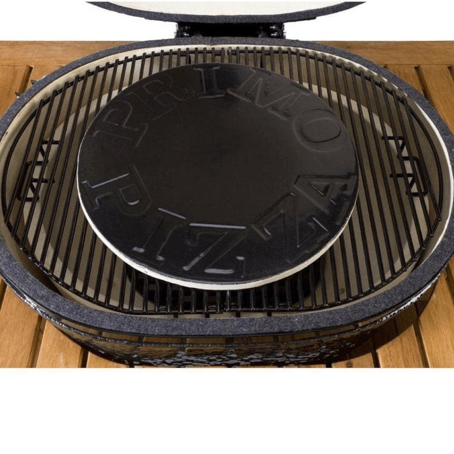 A close-up of a pizza baking on the Primo Ceramic Grills Glazed Ceramic 16" Pizza & Baking Stone inside a grill